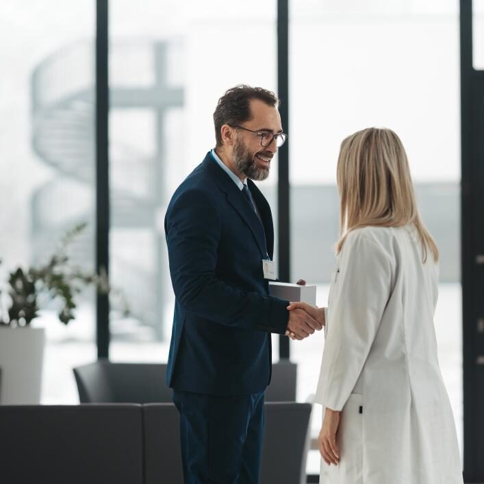 Two professionals shaking hands in office.
